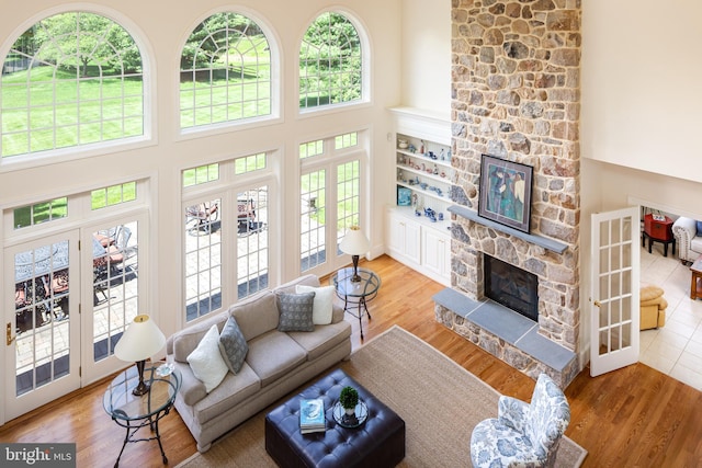 211 Twinings Ln, Wayne, PA 19087 - living room with french doors, a stone fireplace, a high ceiling, and plenty of natural light