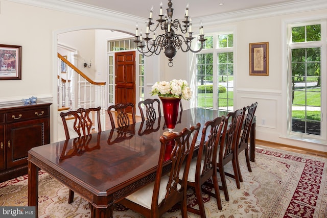 211 Twinings Ln, Wayne, PA 19087 - dining area with a chandelier, arched walkways, ornamental molding, wainscoting, and a decorative wall