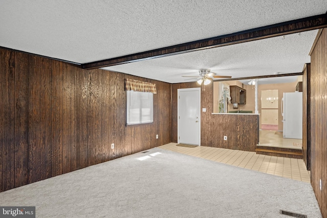 269 Burning Tree Rd, Delran, NJ 08075 - unfurnished living room with wooden walls, a ceiling fan, carpet flooring, and a textured ceiling