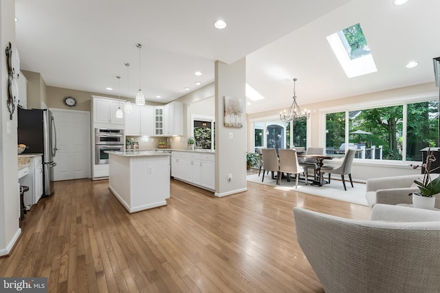 12801 Owlsley Way, Herndon, VA 20171 - kitchen with stainless steel appliances, a kitchen island, a chandelier, a skylight, and light wood finished floors