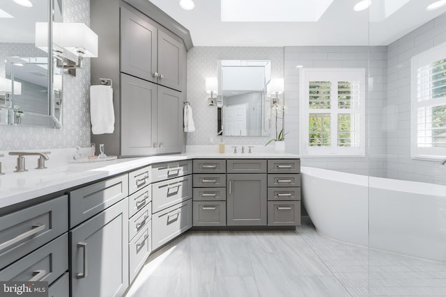 12801 Owlsley Way, Herndon, VA 20171 - bathroom featuring a freestanding bath, double vanity, a skylight, a shower, and a ceiling fan