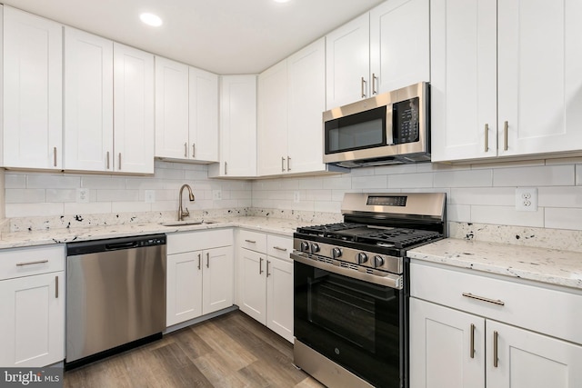 826 Quince Orchard Blvd Unit 101, Gaithersburg, MD 20878 - kitchen with stainless steel appliances, wood finished floors, white cabinets, tasteful backsplash, and recessed lighting