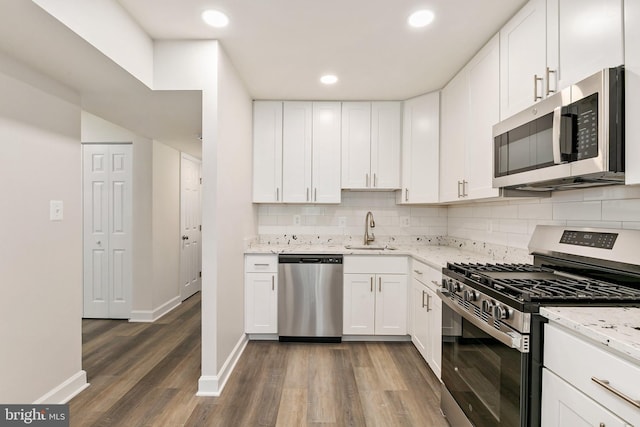 826 Quince Orchard Blvd Unit 101, Gaithersburg, MD 20878 - kitchen featuring stainless steel appliances, dark wood-style flooring, tasteful backsplash, light stone countertops, and white cabinets