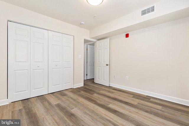 826 Quince Orchard Blvd Unit 101, Gaithersburg, MD 20878 - unfurnished bedroom featuring wood finished floors and a closet
