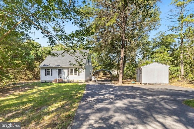 6508 Millcreek Rd, Laurel, DE 19956 - new england style home featuring driveway, a carport, a storage unit, a shingled roof, and a front lawn