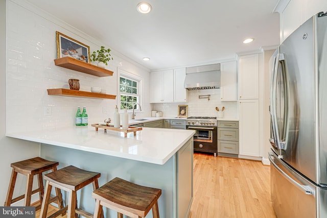 1930 Foxhall Rd, Mclean, VA 22101 - kitchen with appliances with stainless steel finishes, wall chimney exhaust hood, a peninsula, decorative backsplash, and recessed lighting