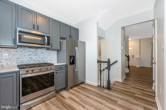 1806 Wheyfield Dr, Frederick, MD 21701 - kitchen with appliances with stainless steel finishes, light wood-style floors, backsplash, light countertops, and vaulted ceiling