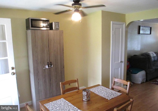 3642 Clarenell Rd, Baltimore, MD 21229 - dining space featuring arched walkways, ceiling fan, and wood finished floors