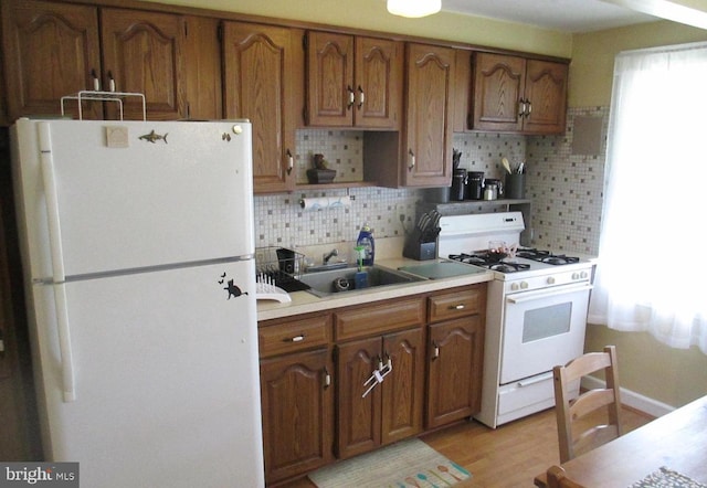 3642 Clarenell Rd, Baltimore, MD 21229 - kitchen with white appliances, decorative backsplash, brown cabinets, and light countertops