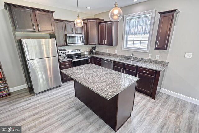 910 Cavalry St, Carlisle, PA 17013 - kitchen featuring stainless steel appliances, dark brown cabinetry, light stone countertops, light wood-style flooring, and a center island