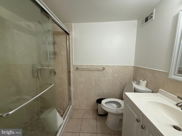 1611 S 28th St, Philadelphia, PA 19145 - bathroom with a shower stall, vanity, tile patterned flooring, tile walls, and a wainscoted wall