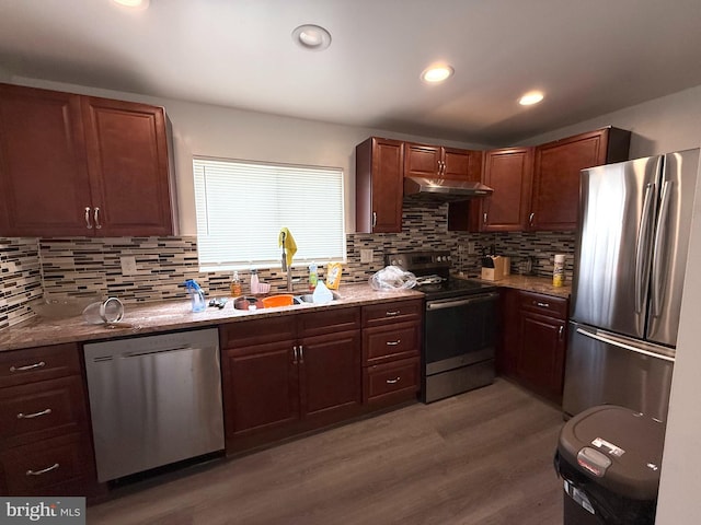 1611 S 28th St, Philadelphia, PA 19145 - kitchen featuring appliances with stainless steel finishes, under cabinet range hood, wood finished floors, tasteful backsplash, and recessed lighting