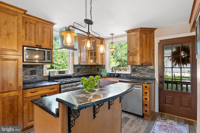 3834 Druck Valley Rd, York, PA 17406 - kitchen with appliances with stainless steel finishes, a kitchen island, dark countertops, and brown cabinetry