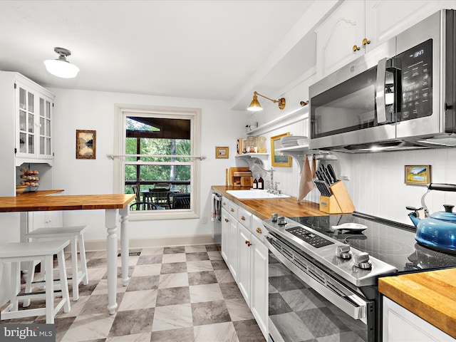 285 Laguna Cir, Severna Park, MD 21146 - kitchen with appliances with stainless steel finishes, wood counters, white cabinetry, and glass insert cabinets