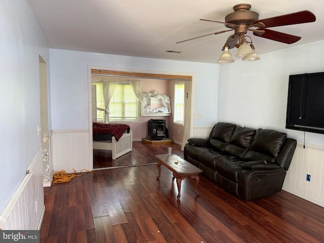4 Brook Ramble Ln, Townsend, DE 19734 - living room with radiator heating unit, a wood stove, wood finished floors, a ceiling fan, and a wainscoted wall