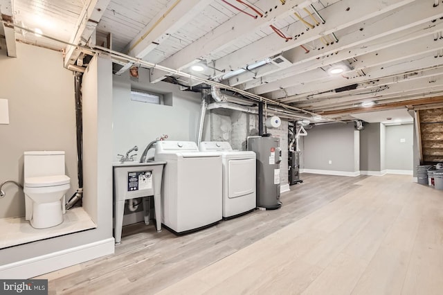3621 Chestnut Ave, Baltimore, MD 21211 - laundry room with water heater, washer and dryer, wood finished floors, and a heating unit