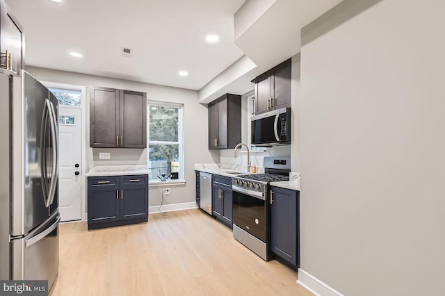 3621 Chestnut Ave, Baltimore, MD 21211 - kitchen featuring stainless steel appliances, light wood finished floors, healthy amount of natural light, recessed lighting, and light stone counters