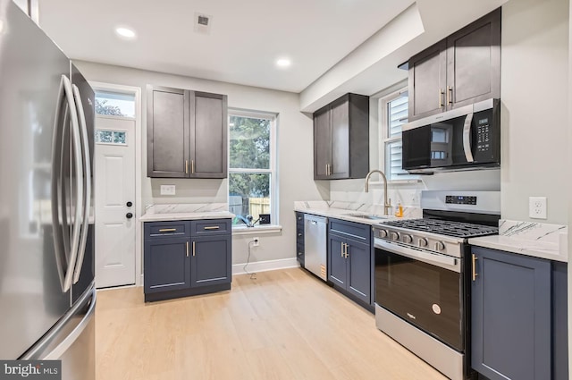 3621 Chestnut Ave, Baltimore, MD 21211 - kitchen featuring appliances with stainless steel finishes, light wood-style flooring, light stone countertops, and recessed lighting