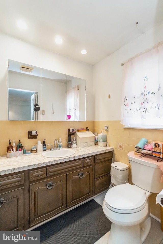 2057 Grove St, Allentown, PA 18104 - bathroom with tile walls, vanity, a wainscoted wall, and recessed lighting