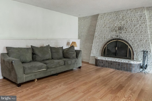 2057 Grove St, Allentown, PA 18104 - living area with wood finished floors, a brick fireplace, and a textured ceiling