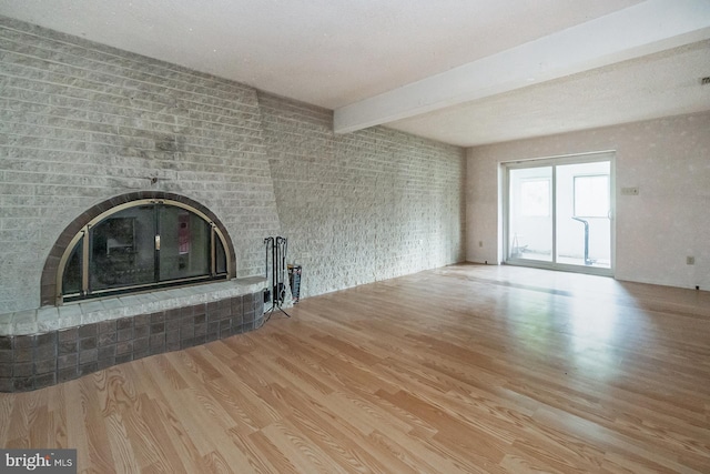 2057 Grove St, Allentown, PA 18104 - unfurnished living room featuring wood finished floors, a fireplace, and beamed ceiling
