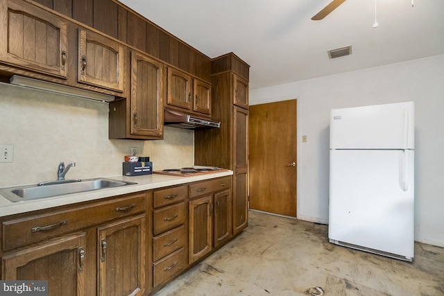 2057 Grove St, Allentown, PA 18104 - kitchen featuring freestanding refrigerator, under cabinet range hood, unfinished concrete flooring, ceiling fan, and light countertops