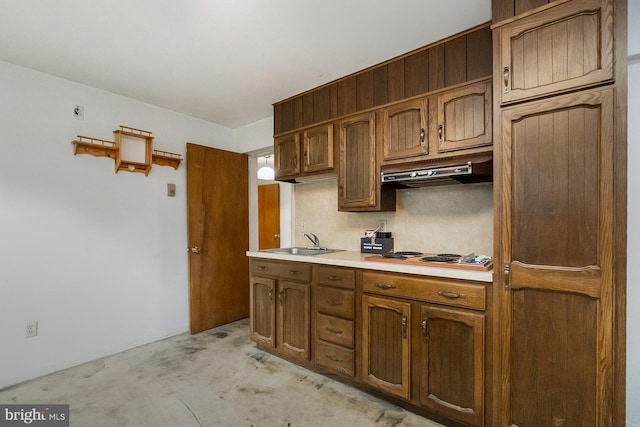 2057 Grove St, Allentown, PA 18104 - kitchen with electric cooktop, under cabinet range hood, light countertops, unfinished concrete floors, and brown cabinetry