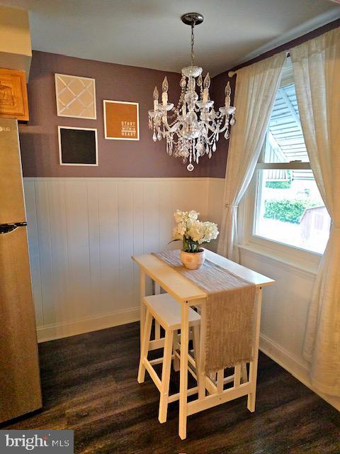 43 Briarcliffe Rd, Glenolden, PA 19036 - dining space with dark wood-style flooring, a chandelier, and wainscoting