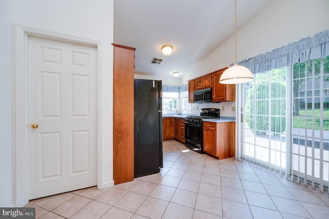 3217 Garfield Ave, Reading, PA 19605 - kitchen with black appliances, brown cabinetry, light tile patterned flooring, light countertops, and hanging light fixtures