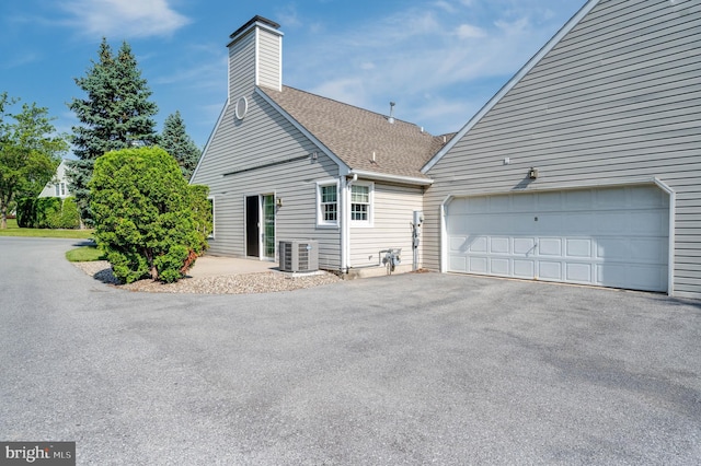 3217 Garfield Ave, Reading, PA 19605 - view of home's exterior featuring a shingled roof, driveway, an attached garage, and a chimney