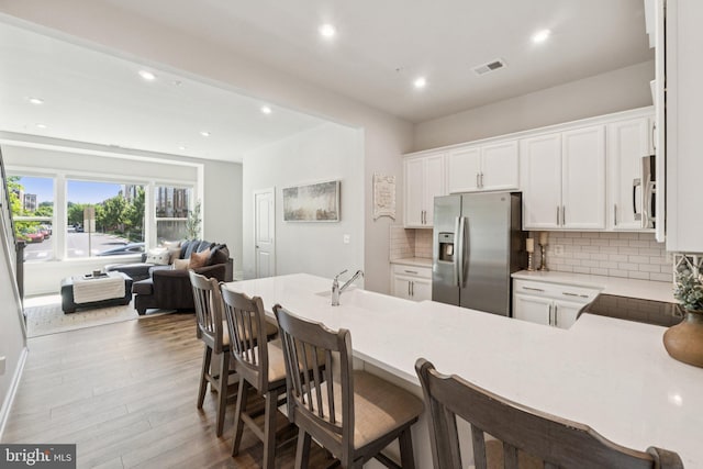 16324 Connors Way Unit 11, Rockville, MD 20855 - kitchen featuring stainless steel fridge, open floor plan, white microwave, wood finished floors, and backsplash