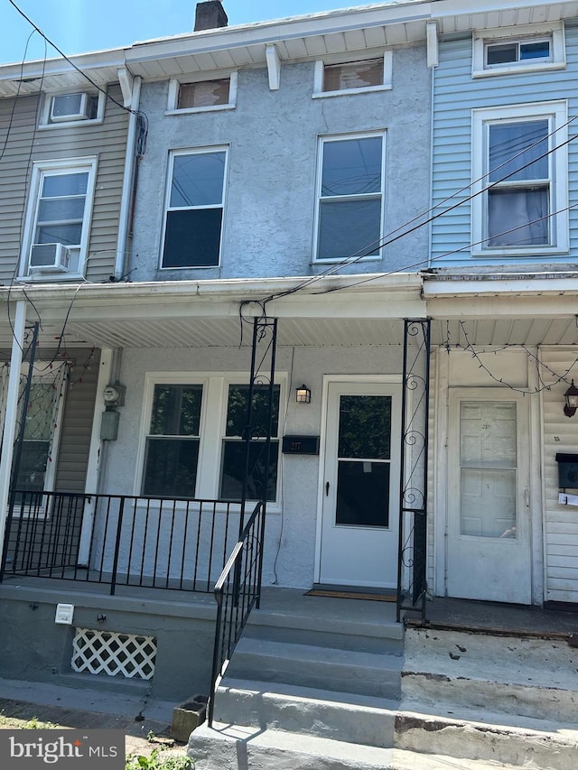 217 Washington St, Trenton, NJ 08611 - view of property with covered porch, stucco siding, a chimney, and cooling unit