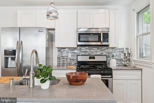 3827 Marshall Rd, Drexel Hill, PA 19026 - kitchen with appliances with stainless steel finishes, white cabinets, decorative backsplash, light stone countertops, and hanging light fixtures