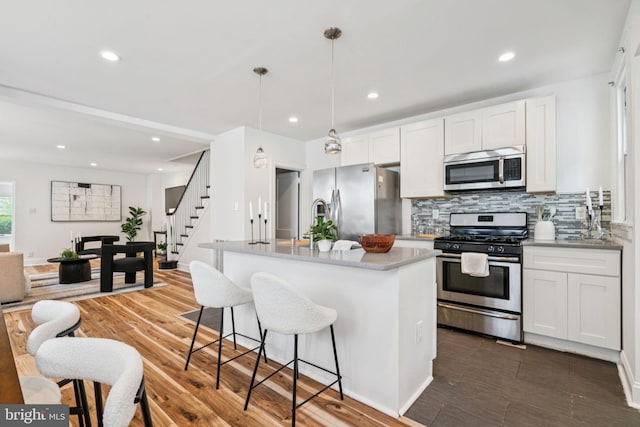 3827 Marshall Rd, Drexel Hill, PA 19026 - kitchen with stainless steel appliances, decorative backsplash, dark wood-type flooring, a kitchen breakfast bar, and white cabinets