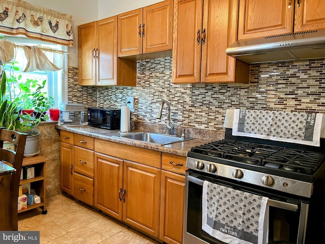 5905 N 3rd St, Philadelphia, PA 19120 - kitchen featuring stainless steel range with gas cooktop, under cabinet range hood, brown cabinets, and backsplash