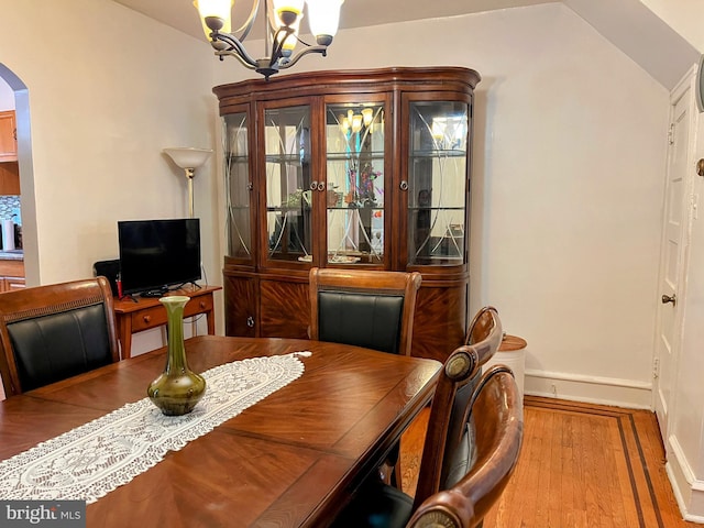 5905 N 3rd St, Philadelphia, PA 19120 - dining area with arched walkways, wood finished floors, a chandelier, and vaulted ceiling