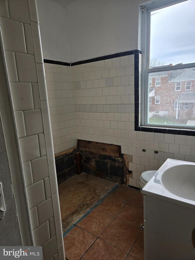 2660 Park Heights Ter, Baltimore, MD 21215 - bathroom featuring healthy amount of natural light, tile walls, tile patterned floors, and vanity