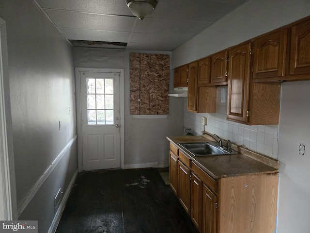 2660 Park Heights Ter, Baltimore, MD 21215 - kitchen with dark wood-style floors, decorative backsplash, brown cabinets, and under cabinet range hood