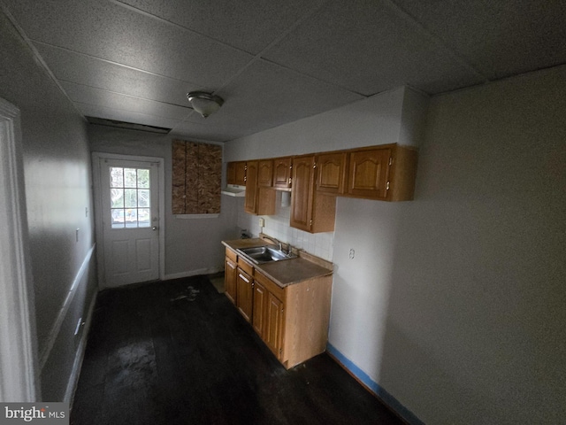 2660 Park Heights Ter, Baltimore, MD 21215 - kitchen featuring a drop ceiling, tasteful backsplash, brown cabinetry, and dark wood-type flooring