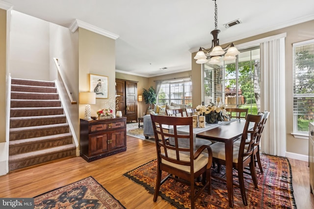 45050 Brae Ter Unit 101, Ashburn, VA 20147 - dining room with a chandelier, ornamental molding, light wood finished floors, and stairway