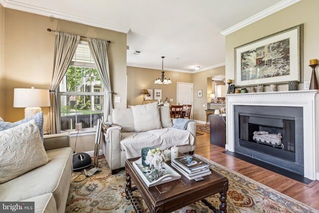 45050 Brae Ter Unit 101, Ashburn, VA 20147 - living area featuring wood finished floors, a chandelier, ornamental molding, and a fireplace with flush hearth