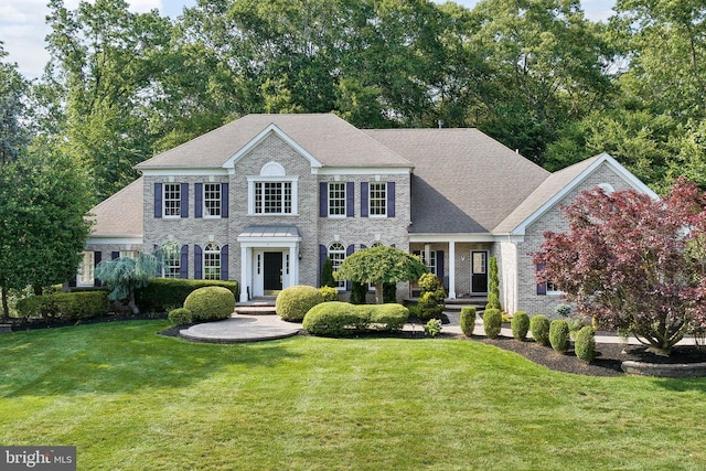 7 Shady Brook Ln, Cranbury, NJ 08512 - colonial house featuring a front lawn, roof with shingles, and brick siding