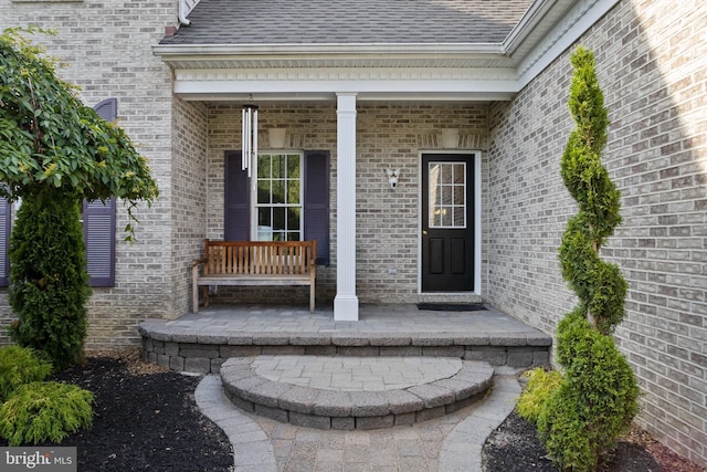 7 Shady Brook Ln, Cranbury, NJ 08512 - view of exterior entry featuring covered porch, brick siding, and roof with shingles