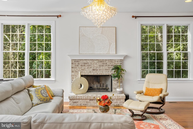 7 Shady Brook Ln, Cranbury, NJ 08512 - living area with wood finished floors, a chandelier, plenty of natural light, and a brick fireplace