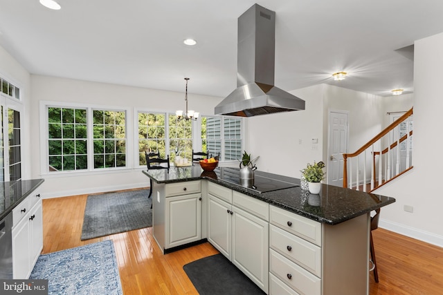 7 Shady Brook Ln, Cranbury, NJ 08512 - kitchen featuring island range hood, black electric cooktop, light wood finished floors, a chandelier, and white cabinets
