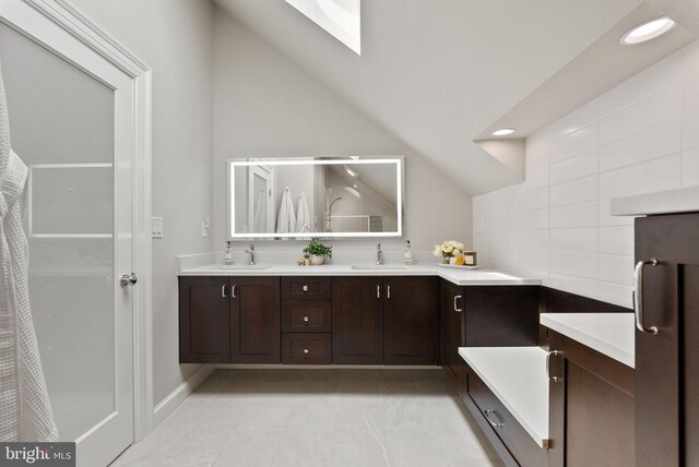 304 Summers Dr, Alexandria, VA 22301 - full bathroom with double vanity, tile patterned floors, a skylight, vaulted ceiling, and recessed lighting