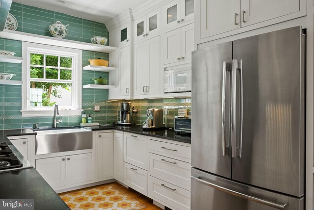 304 Summers Dr, Alexandria, VA 22301 - kitchen featuring freestanding refrigerator, dark countertops, backsplash, and white cabinetry