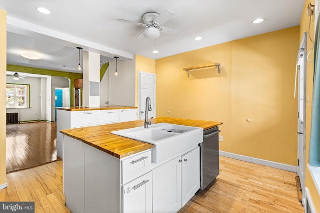 1148 S 12th St, Philadelphia, PA 19147 - kitchen featuring wood counters, ceiling fan, stainless steel dishwasher, an island with sink, and white cabinetry