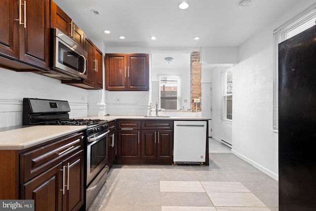 539 Fernon St, Philadelphia, PA 19148 - kitchen featuring appliances with stainless steel finishes, light countertops, light tile patterned floors, recessed lighting, and ornate columns