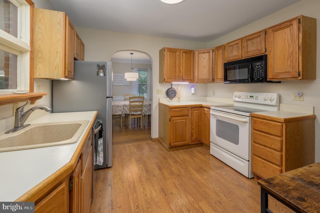 416 Copley Rd, Haddonfield, NJ 08033 - kitchen with black microwave, white electric range oven, arched walkways, light wood-type flooring, and light countertops